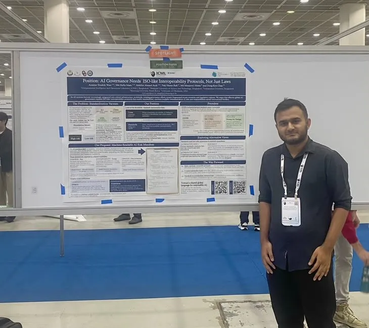Standing beside a poster on AI governance interoperability protocols